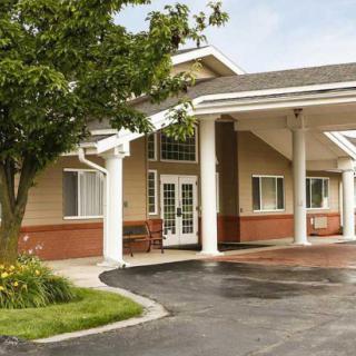 A hotel entrance with a covered driveway and surrounding greenery.