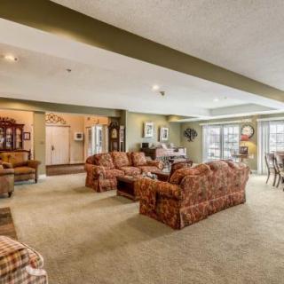 A spacious living room with ample seating, featuring patterned sofas and natural lighting.