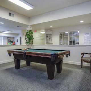 A spacious indoor recreation room featuring a pool table and seating area.