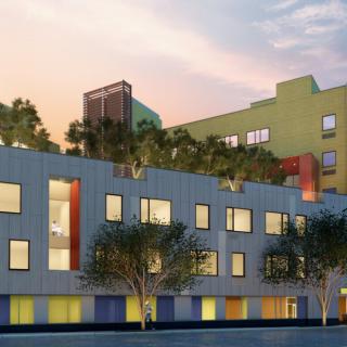 A modern, multi-colored urban building with trees on the rooftop.