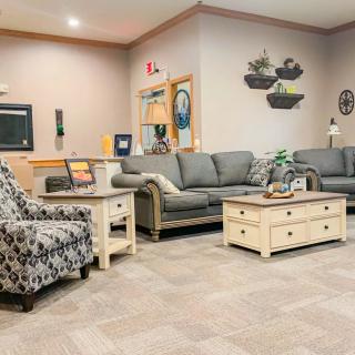 A cozy living room featuring a set of sofas, an armchair, and a coffee table with decorative elements.