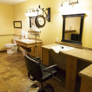 A well-appointed salon area featuring a vanity, mirror, and styling chair.