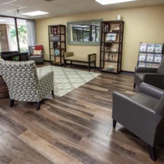 A cozy waiting room with comfortable chairs and bookshelves.