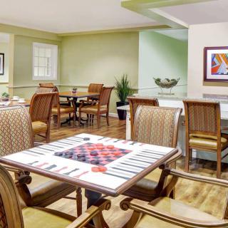 A cozy living room featuring a variety of chairs and tables, adorned with colorful artwork and decorations.
