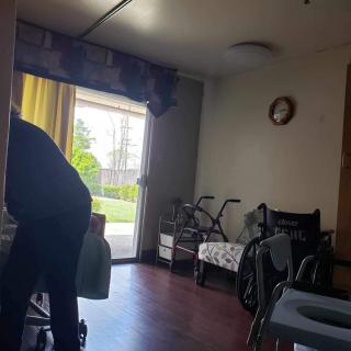 A room with a wheelchair and walker near the window.
