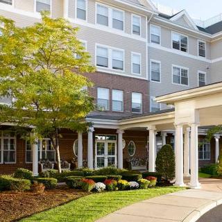 A well-maintained residential building with landscaped gardens and a covered entrance.