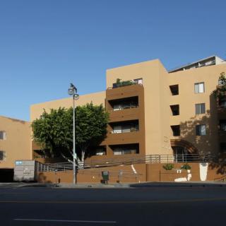 A view of a residential apartment building from the street on a clear day.