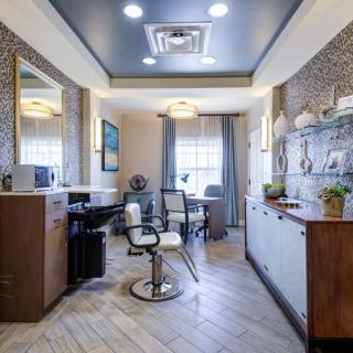Modern hair salon interior with a styling chair, mirrors, and decorative elements.