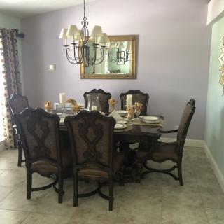 A well-decorated dining room with a large table, chairs, and a chandelier.
