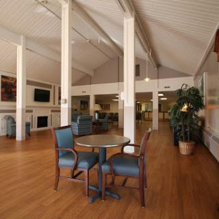 A spacious and inviting lounge area featuring comfortable seating and a warm wooden floor.