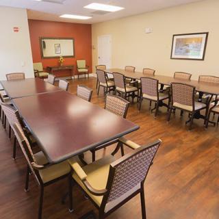 An empty conference room with long tables and chairs arranged neatly.