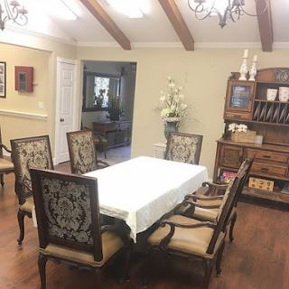 A cozy and elegantly designed dining room featuring a wooden table and intricately patterned chairs.