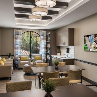 A modern living room with a kitchen area, featuring elegant furniture and lighting.