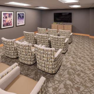 A cozy home theater room with comfortable seating and a large television.