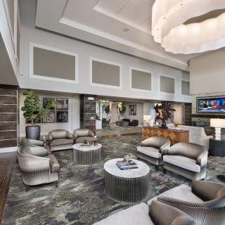 A luxurious and spacious modern living room with contemporary furnishings and a large chandelier.