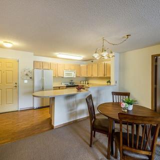 A cozy open-plan kitchen and dining area with wooden cabinetry and a round dining table.
