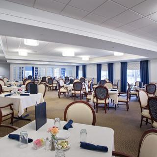 An elegantly set dining room with neatly arranged tables and chairs.