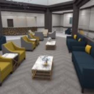 A modern lobby featuring comfortable seating with sofas and chairs arranged around coffee tables.