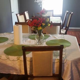 A well-arranged dining room table with a floral centerpiece and green placemats.