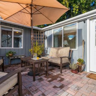 Cozy patio area with comfortable seating and an umbrella, perfect for relaxation.