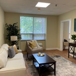 A cozy living room with comfortable seating, decorative plants, and natural lighting.