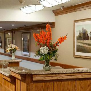 A welcoming reception area adorned with vibrant flower arrangements and paintings.
