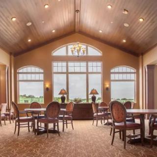 A well-lit dining room with large windows and elegant furniture.