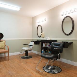 A cozy hair salon setup featuring stylish chairs and mirrors.