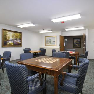 A well-lit conference room with several tables and chairs, decorated with artwork on the walls.