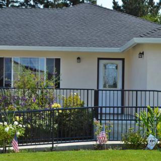 A quaint house with a small garden and flags in the front yard.