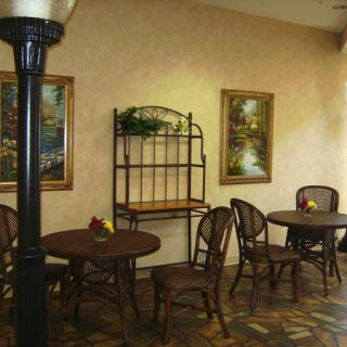 Cozy interior with round tables, wicker chairs, and decorative wall paintings.