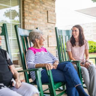 A heartwarming moment shared among family members enjoying a conversation on a porch.