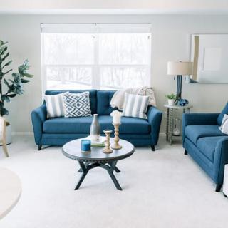 A modern living room featuring blue couches, a stylish coffee table, and decorative accents.