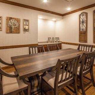 A cozy dining room featuring a wooden table and chairs, complemented by elegant wall art and modern lighting.