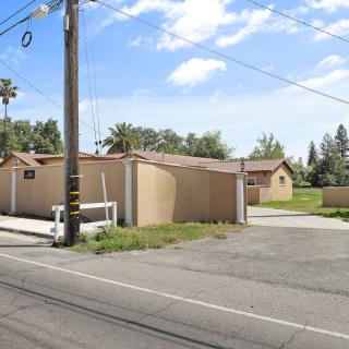 A view of a suburban neighborhood with beige houses and palm trees under a clear blue sky.