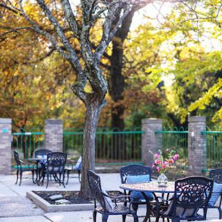 A serene outdoor patio area surrounded by vibrant autumn foliage, perfect for relaxation.