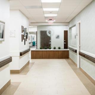 A clean and well-lit corridor in a hospital setting, featuring modern design elements.