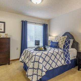 A well-decorated bedroom with blue and white bedding and matching curtains.