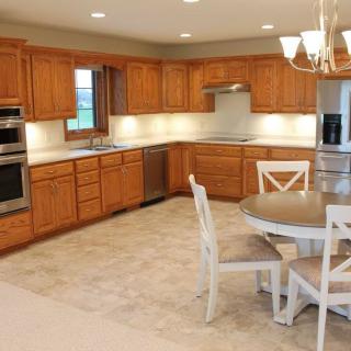 A modern kitchen with wooden cabinets and a dining area.