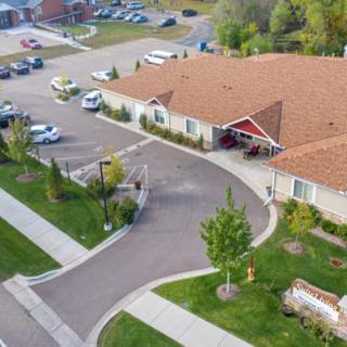 Aerial view of a suburban residential building with a parking lot and landscaped surroundings.