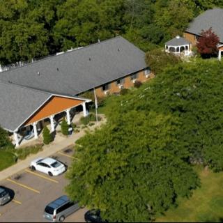 An aerial view of a building with a parking lot surrounded by trees.