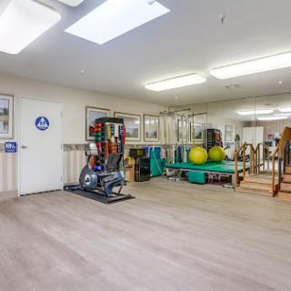 A spacious fitness studio equipped for various exercises and rehabilitation activities.