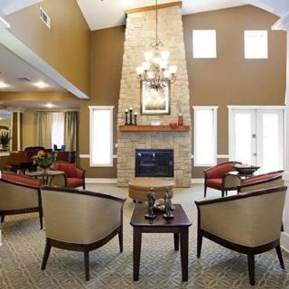 A cozy living room featuring modern furniture and a stone fireplace.