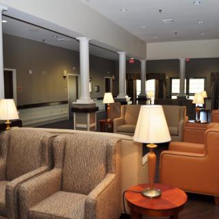 A spacious hotel lobby featuring comfortable armchairs and warm lighting.