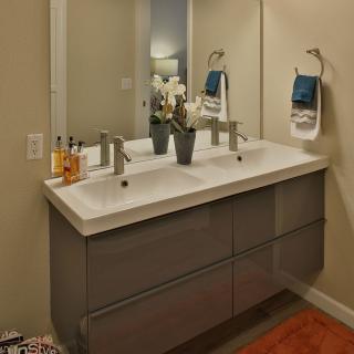 A modern bathroom with a double sink vanity and neatly arranged towels.
