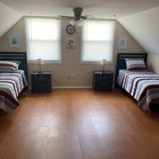 A minimalist attic bedroom with twin beds and wooden flooring.