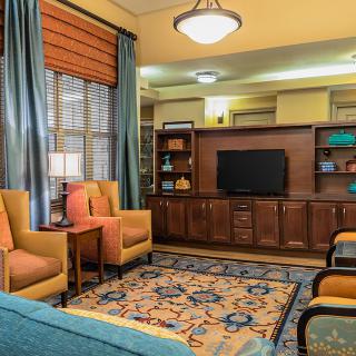 A cozy living room with comfortable armchairs, a television, and elegant decor.