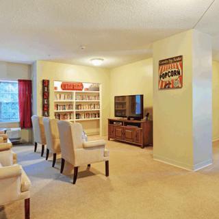 A cozy living room with comfortable seating, a television, and a bookshelf.