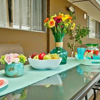 A beautifully set outdoor dining table with colorful flowers and fruit decorations.