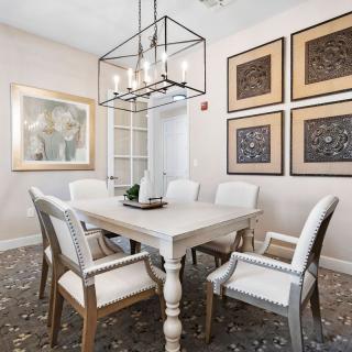 A beautifully decorated dining room featuring a stylish chandelier and artwork on the walls.